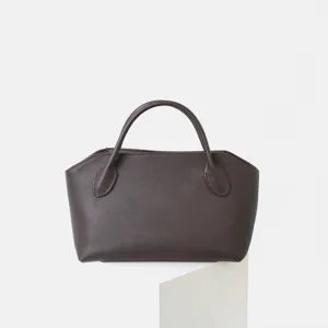 Gros plan sur la texture et la conception de la poignée du sac à main en cuir marron.