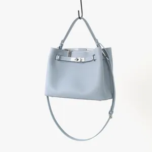 Sac cabas bandouliere en cuir bleu clair avec poignee superieure et fermoir en metal.