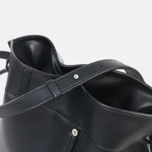 Détail de sac bandoulière hobo en cuir noir, sac seau en cuir souple avec détails métalliques.