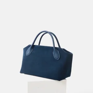 Vue détaillée du sac à main en cuir nubuck bleu foncé, cabas minimaliste rétro pour bureau.