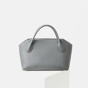 Vue détail d'un sac à main minimaliste en cuir de vachette gris, élégant cabas rétro.