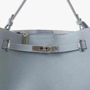 Gros plan détaillé d'un sac cabas en cuir véritable bleu clair avec fermeture métallique.