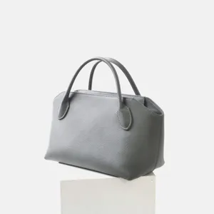 Vue détaillée d'un élégant sac à main gris en cuir véritable avec une texture raffinée.