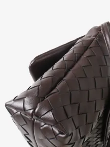 Sac bandoulière à rabat tressé en cuir marron foncé, style classique chic et élégant.