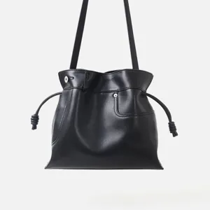 Vue détaillée du sac porté épaule hobo en cuir souple noir avec cordon de serrage noué.