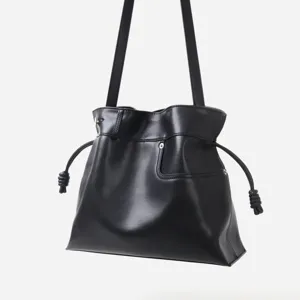 Detail du sac seau noir en cuir souple avec cordon de serrage, sac porte epaule hobo chic.