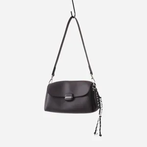Detalle de bolso bajo el brazo de cuero marrón oscuro, piel suave con hebilla y tachuelas.