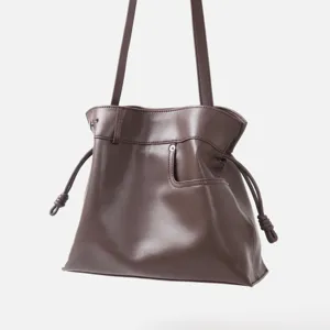 Détail sac porté épaule hobo en cuir souple marron, sac seau cordon tendance femme.