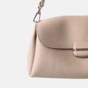 Primer plano detallado de bolso de hombro de cuero suave con cierre y anillo metálicos.