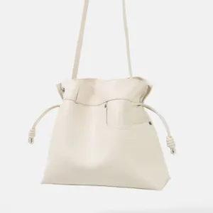 Sac a main en cuir creme detail montrant texture douce, cordon serre et noeuds lateraux.