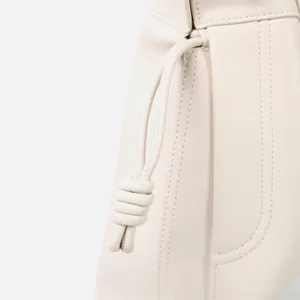 Vue détaillée du sac seau hobo souple en cuir crème pour femmes avec nœud coulissant.