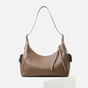Primer plano del bolso de hombro de cuero marrón que muestra la textura y el bolsillo.
