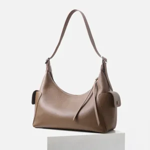Detalle de bolso de hombro marrón, de cuero genuino texturizado con prácticos bolsillos.
