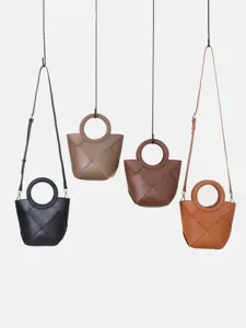 Stylish woven leather crossbody handbag with circular top handle, chic geometric design.