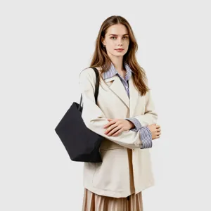 Vista detallada del bolso hobo de lona negra, gran capacidad y diseño elegante para el uso diario.