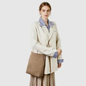 Vista dettagliata della borsa tote in camoscio marrone indossata da una modella in stile professionale.