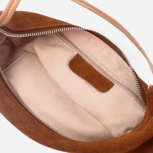 Detalle de bolso de hombro de ante retro, forro interior con bolsillo con cremallera.
