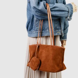 Detalle del bolso tote de ante marrón que muestra la textura y el monedero a juego.