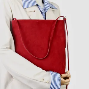 Vista dettagliata della borsa tote in camoscio rosso con texture fine ed elegante stile.