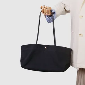 Bolso tote de lona negra vista detallada, diseño minimalista con correas finas, ideal oficina.