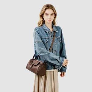 Vista detallada del elegante bolso de hombro de cuero marrón llevado por la modelo.
