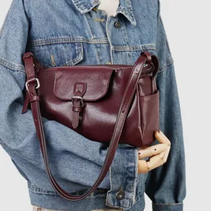 Vista detallada del bolso de hombro de cuero rojo oscuro para mujer con detalle de hebilla.