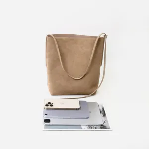 Borsa a secchiello in camoscio marrone che mostra grande capienza con dispositivi.