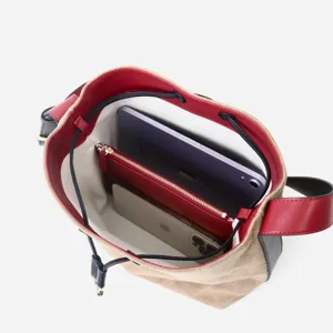 Vista detallada del bolso cubo de lona bicolor que muestra gran capacidad y compartimentos.