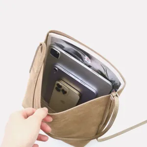 Vista dettagliata della capacità interna della borsa a secchiello in suede con tablet.