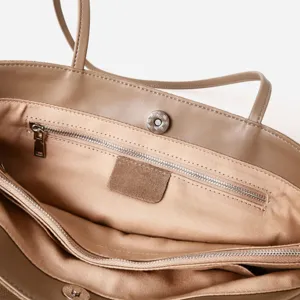 Detalle interior del bolso de piel con bolsillo con cremallera y cierre magnético.