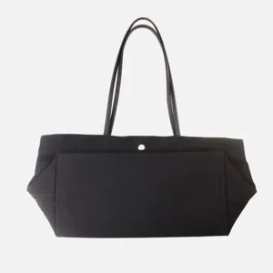 Bolso de hombro minimalista negro de lona con asas de cuero ideal para uso diario.