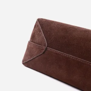 Dettaglio borsa a mano in pelle scamosciata marrone, borsa a spalla minimal per donna.