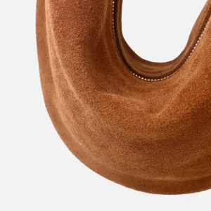 Detalle de bolso de hombro de ante marrón retro, elegante bolso hobo de axila para otoño e invierno.