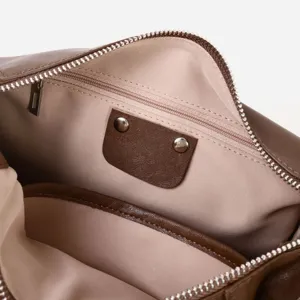 Vista detallada del interior del bolso de mujer de cuero marrón con forro de tela y cremallera.