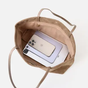 Vista detallada de un bolso tote de ante grande que muestra su capacidad de almacenamiento.