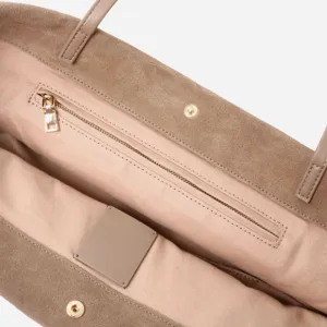 Detalle interior del bolso tote de ante marrón con forro de tela y bolsillo con cremallera.