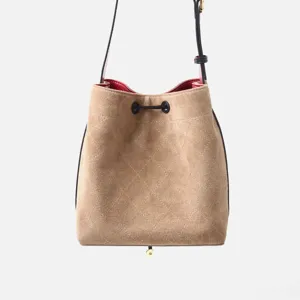 Bolso cubo acolchado de ante con cordon ajustable y forro rojo para mujeres detalle.