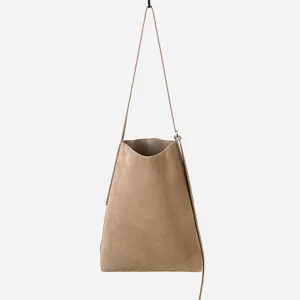 Dettaglio della borsa a secchiello in pelle scamosciata minimalista, design appeso.