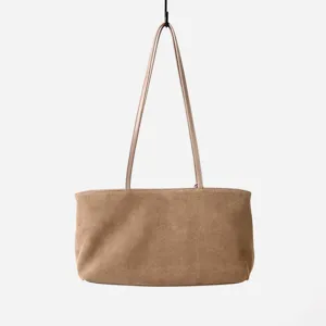 Detalle de la correa del bolso hobo de ante marrón, estilo minimalista, accesorio elegante.