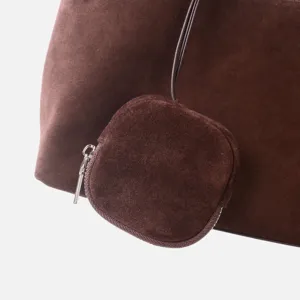 Primer plano detalle de la textura del bolso hobo de cuero gamuza marron oscuro y cremallera