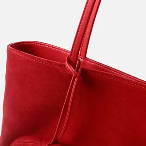 Primer plano del detalle de la correa y el nudo elegante del bolso hobo de ante rojo
