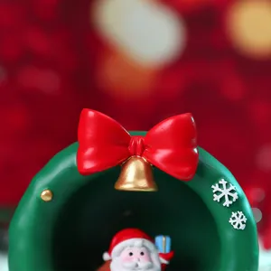 Close-up detail of Christmas wreath decor featuring a red bow, golden bell, and Santa figure.
