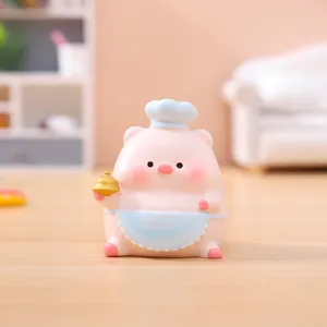 Cute resin pig figurine wearing chef hat and apron holding bell for car desktop decor detail view
