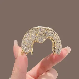 Vue détaillée pince à cheveux strass étincoyants sur métal doré, élégant accessorio de coiffure.