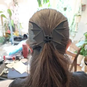 Vue detaillee d une pince a cheveux noire en forme de chauve souris pour Halloween.
