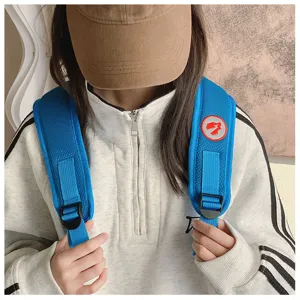 Blue mesh backpack shoulder strap with adjustable buckle and cute embroidered monster patch detail.