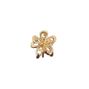 Detaillierte Nahaufnahme einer Miniatur-Metallblumen-Haarklammer in glänzendem Gold-Finish.