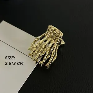 Nahaufnahme einer gotischen goldenen Skeletthand Haarklammer mit kompakter Größe.