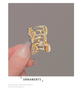 Gros plan d'une pince à cheveux en métal doré avec un design de nœud creux exquis.