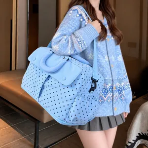 Detailed shot of the blue polka dot travel bag worn by a model, showing capacity and style.